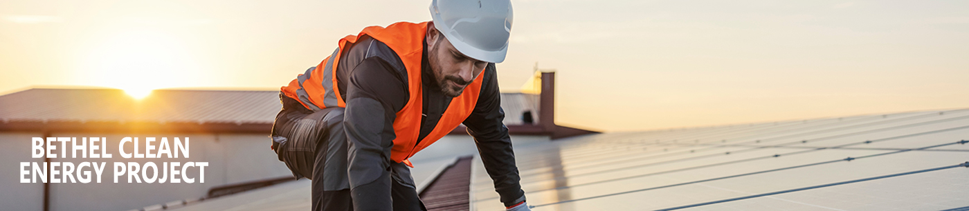 A worker is fixing solar panels on the roof.