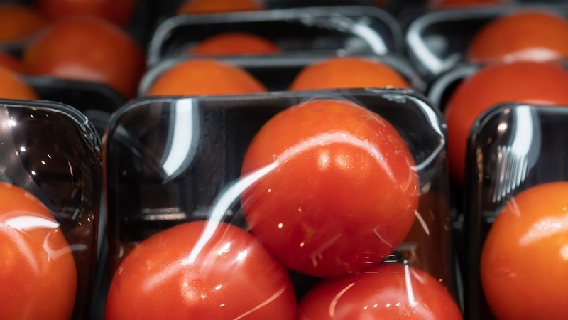 Tomatoes in plastic tray and plastic wrap packaging